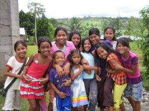 Group of children in the Philippines smiling and holding each other